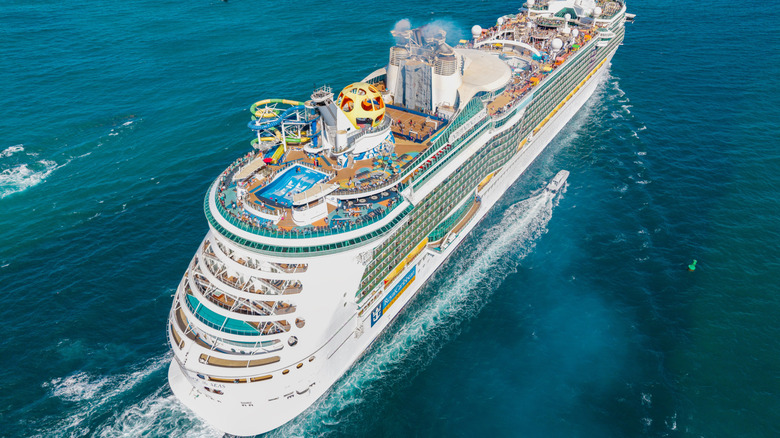 An aerial shot of a cruise ship sailing through the ocean.