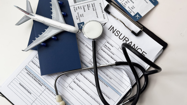 Travel documents under a model airliner and a stethoscope