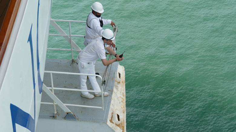 two ship officers on the deck of a cruise ship
