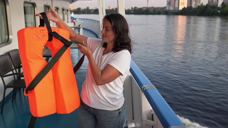 woman demonstrates life jacket use on cruise ship