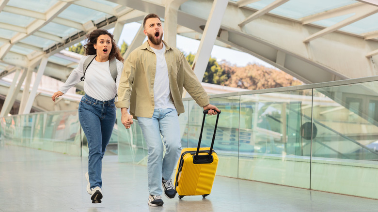 nervous couple running in an airport