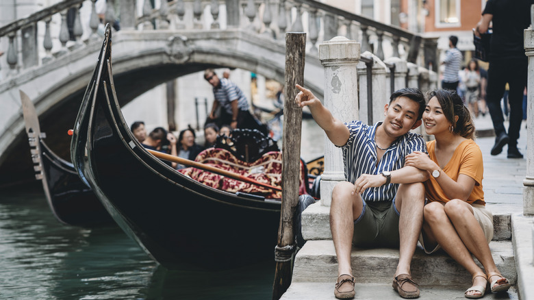 a couple next to a canal in venice