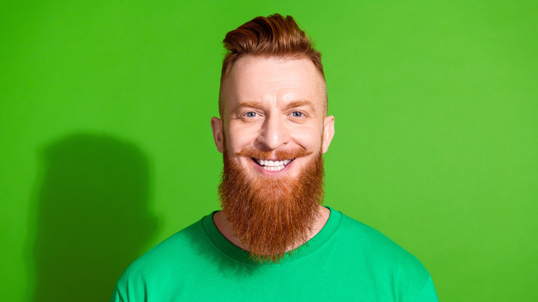 A red-haired man with a long beard smiles