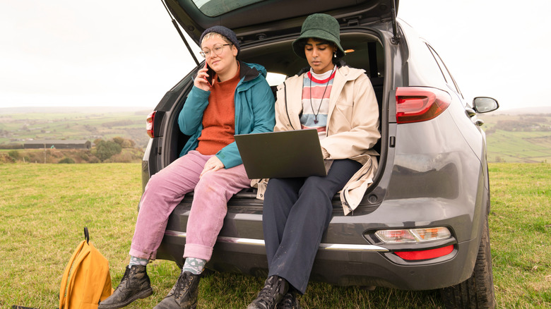 cheerful man and woman packing clothes into travel suitcase.