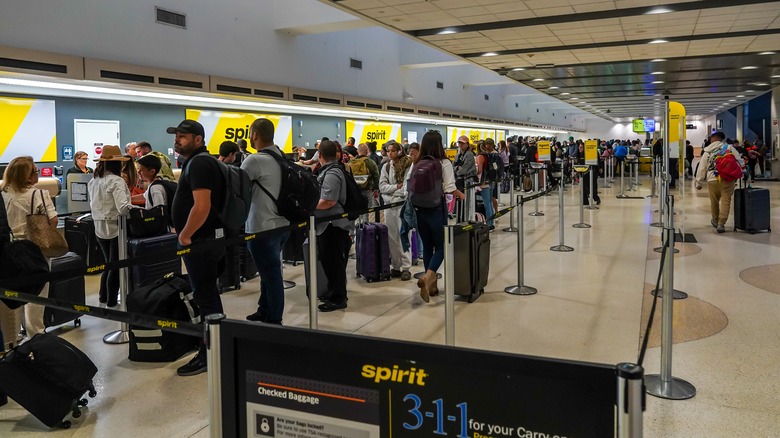 airport passengers line up at the Spirit Airlines counter