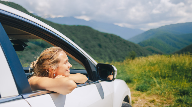 woman relaxed in a car enjoying beautiful nature view