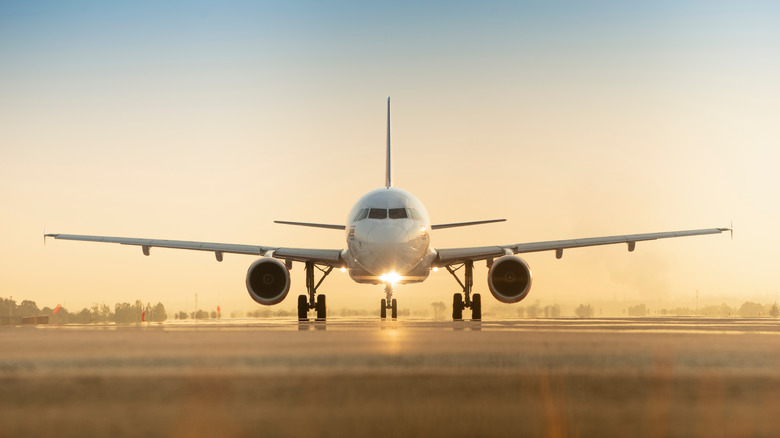 airplane on runway at sunset