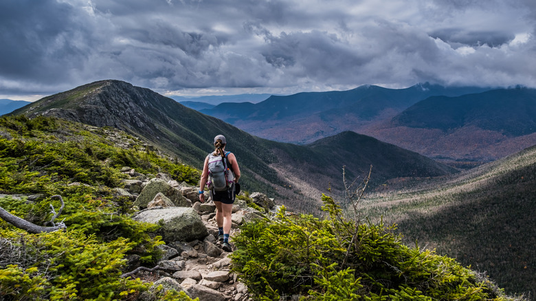 A woman hiking along a mountain crest trail
