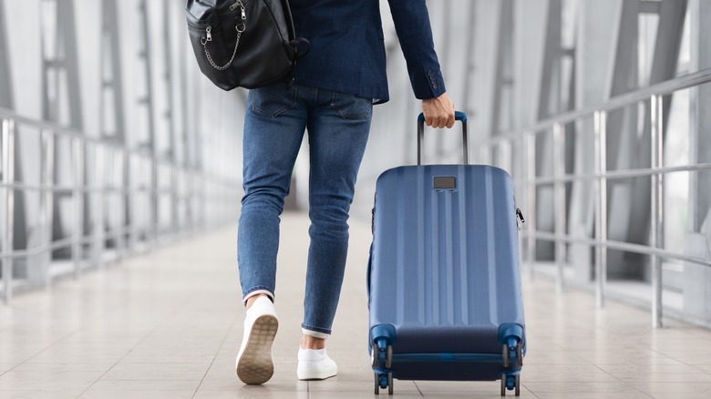 man pulling hand luggage