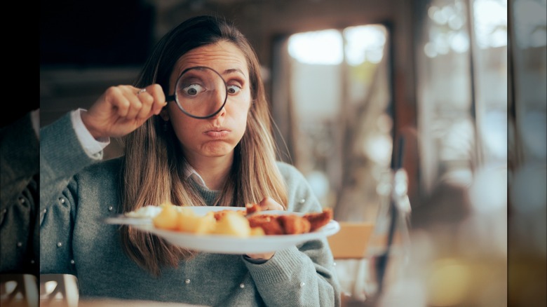 woman looking closely at food