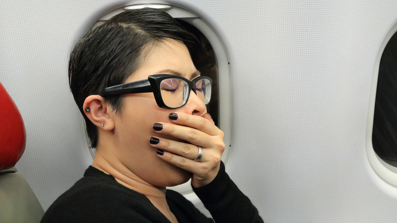 Person yawning on airplane