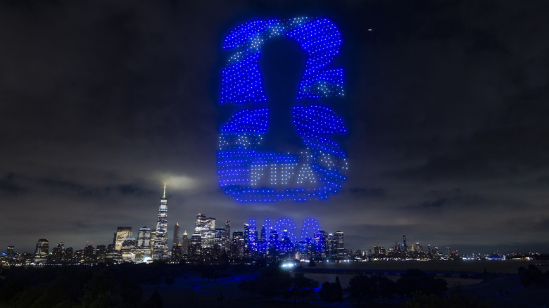 The FIFA World Cup logo lit up over the Manhattan skyline at night.
