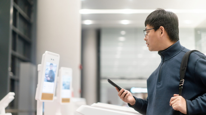 Asian man boarding the plane with facial recognition