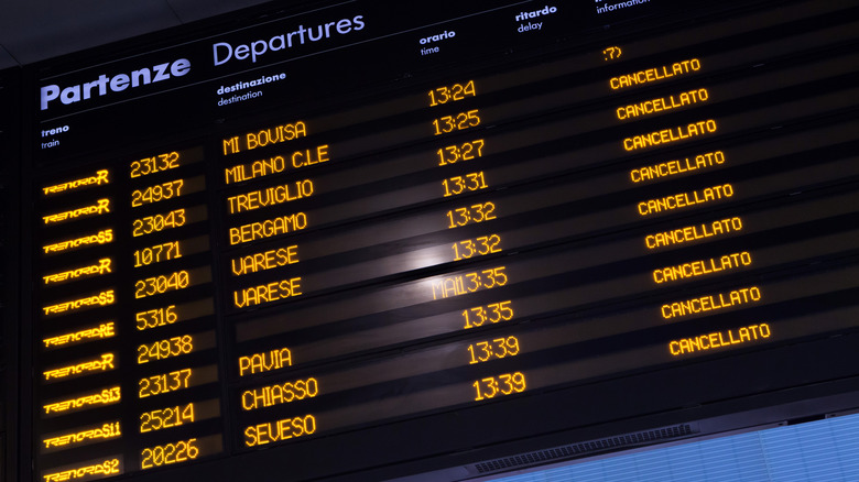 An Italian train station departure board with cancelled trains listed