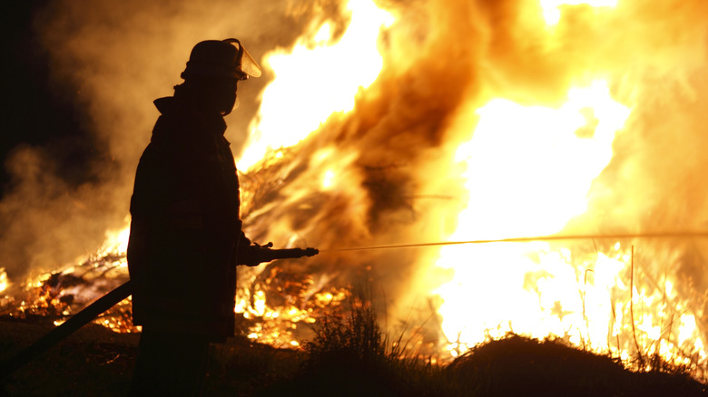 A fireman fighting an outdoor blaze.