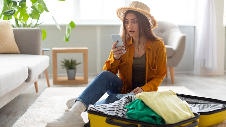 Surprised traveler looking at phone