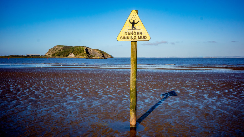 Quicksand warning post on beach