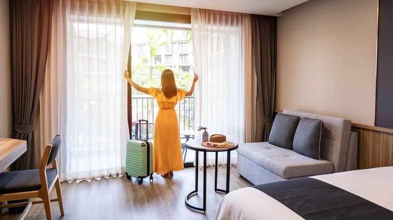 woman looking out hotel window 