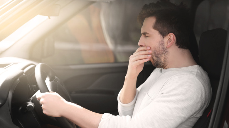 Man yawning while driving car
