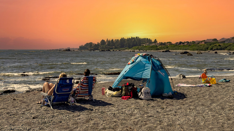 two people and their kid play on the Oregon coast with a tent