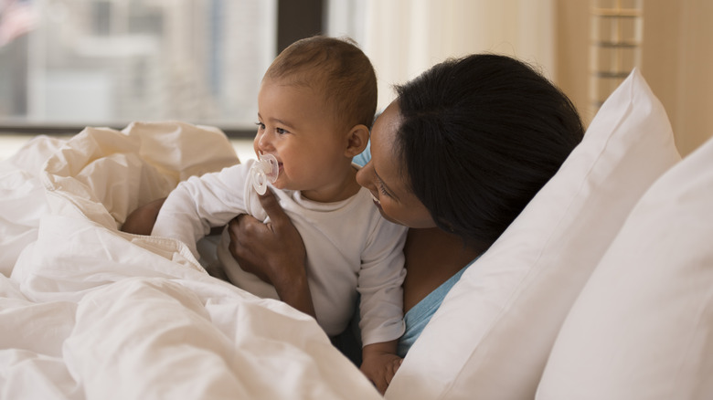 laughing baby on white sheets