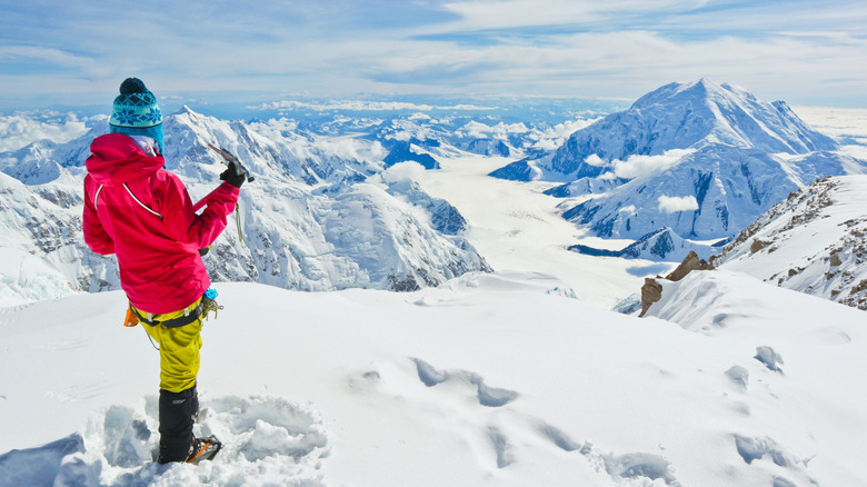 Brightly dressed climber overlooking snowy peaks