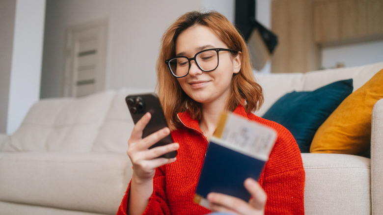 woman with passport booking travel on phone