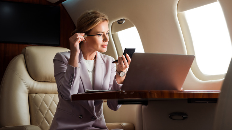 woman doing makeup on airplane