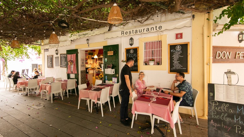 restaurant attendant attending to man and woman
