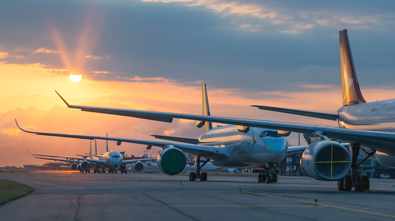 a line of airlcraft waiting on the runway