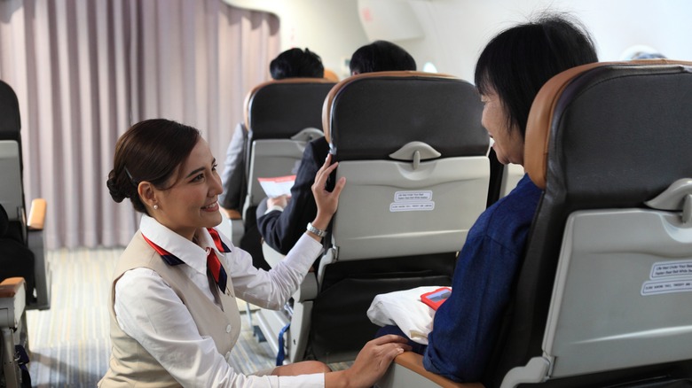 Flight attendant talking to passenger