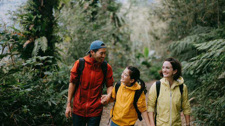 family hiking through forest trail