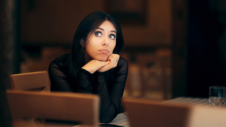A woman in a chair looks alarmed.
