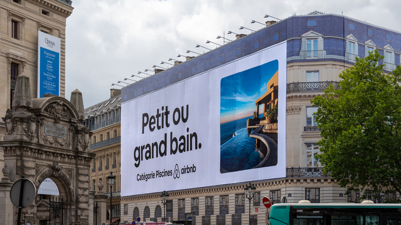 A huge Airbnb ad covers the scaffolding on a Parisian building.