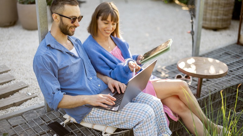 digital nomad couple work on computer 