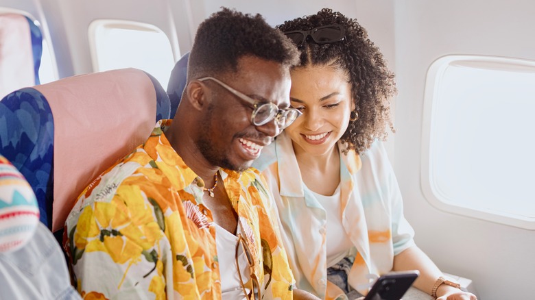 passengers on plane with phone