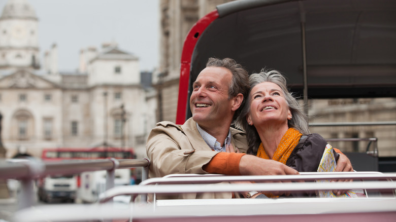 An older couple enjoying a ride on a tour bus.