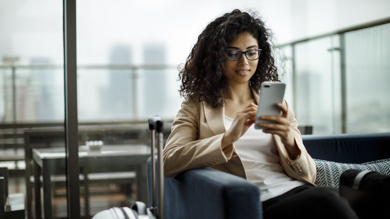 woman with suitcase using phone