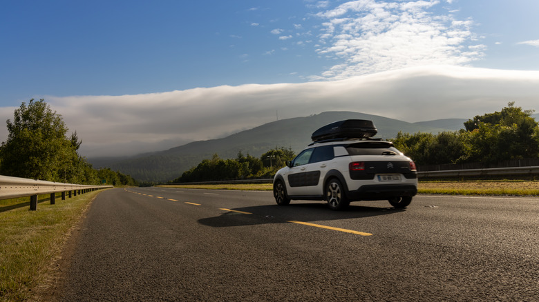 white car driving on road