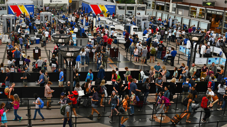 A crowd of travelers lined up to go through airport security.
