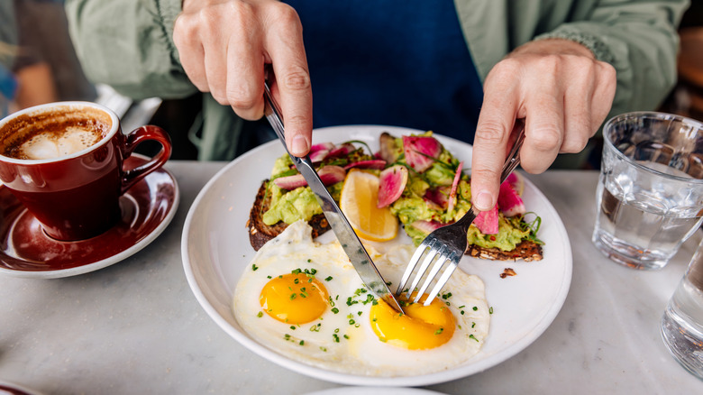 A customer eats eggs and salad in a restaurant