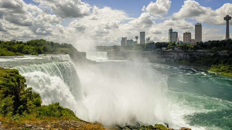 Niagara Falls tumbles in foreground with high rises in background