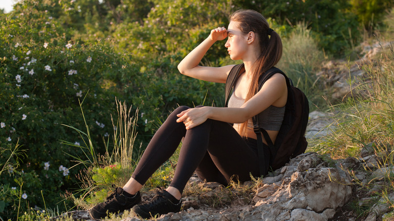 woman in backpack and sports bra