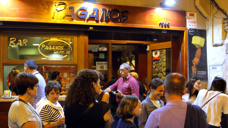 Customer pass by a busy tapas bar in Spain