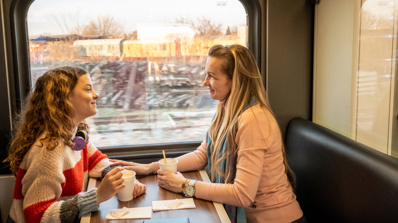 Two women having coffee on a train.