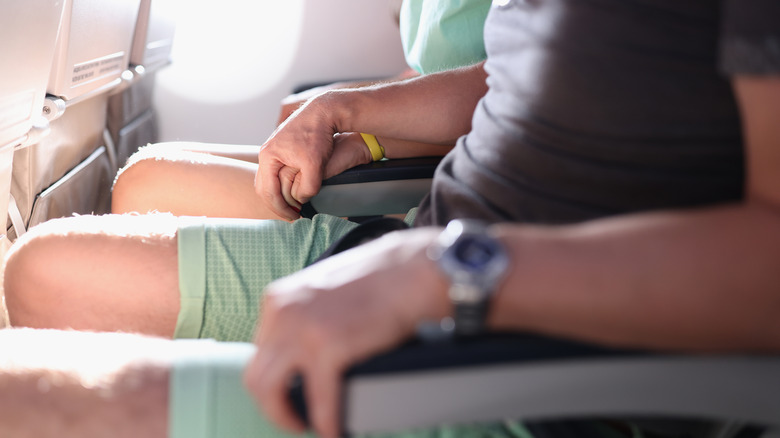 nervous airplane passengers holding hands