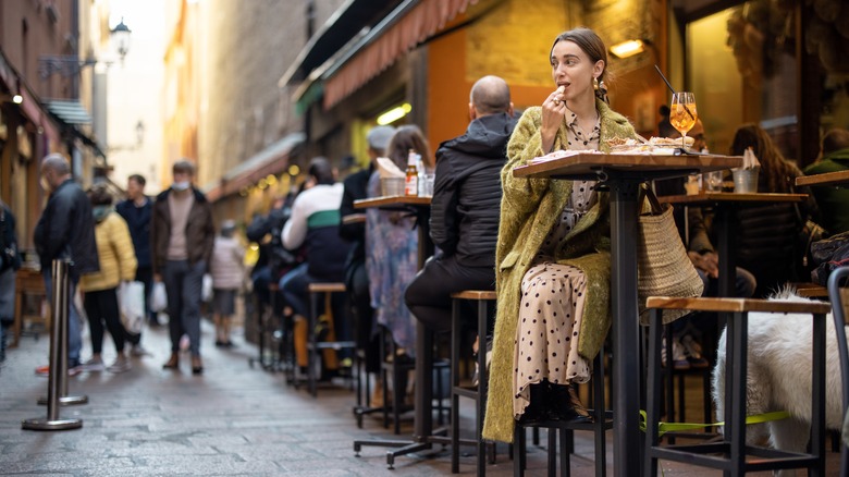 Woman sitting at patio restaurant in Italy