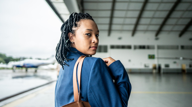 Person with nose and ear piercings in hangar.