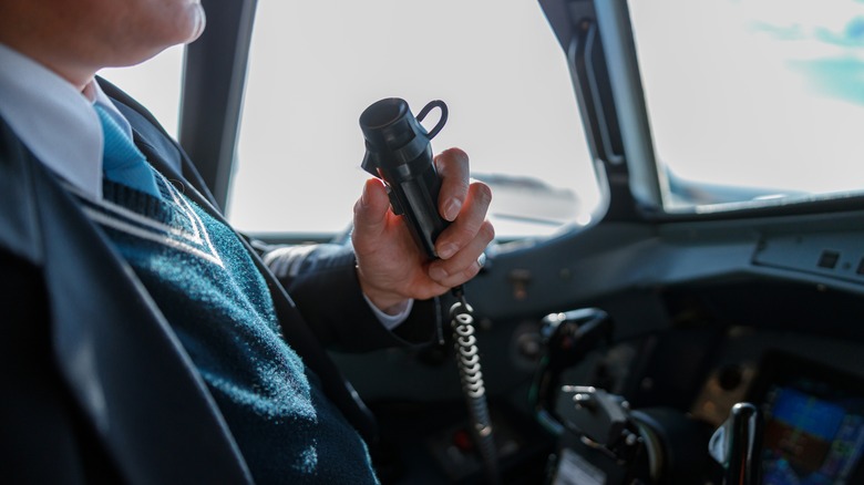 Pilot using aircraft radio in cockpit