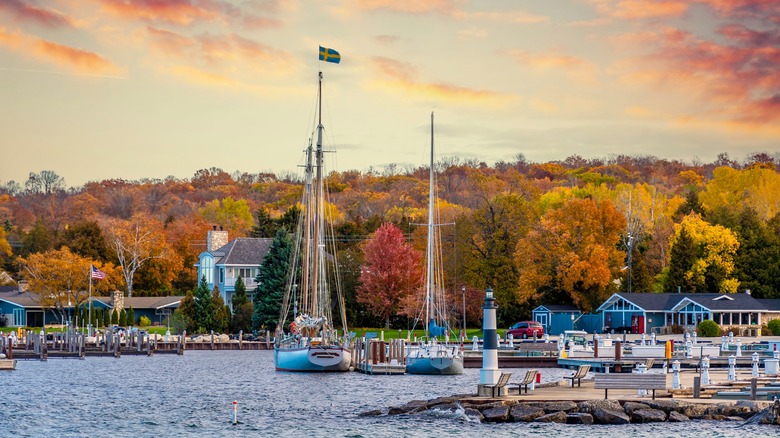 Sail boats in Sister Bay Harbor with autumn trees in the background